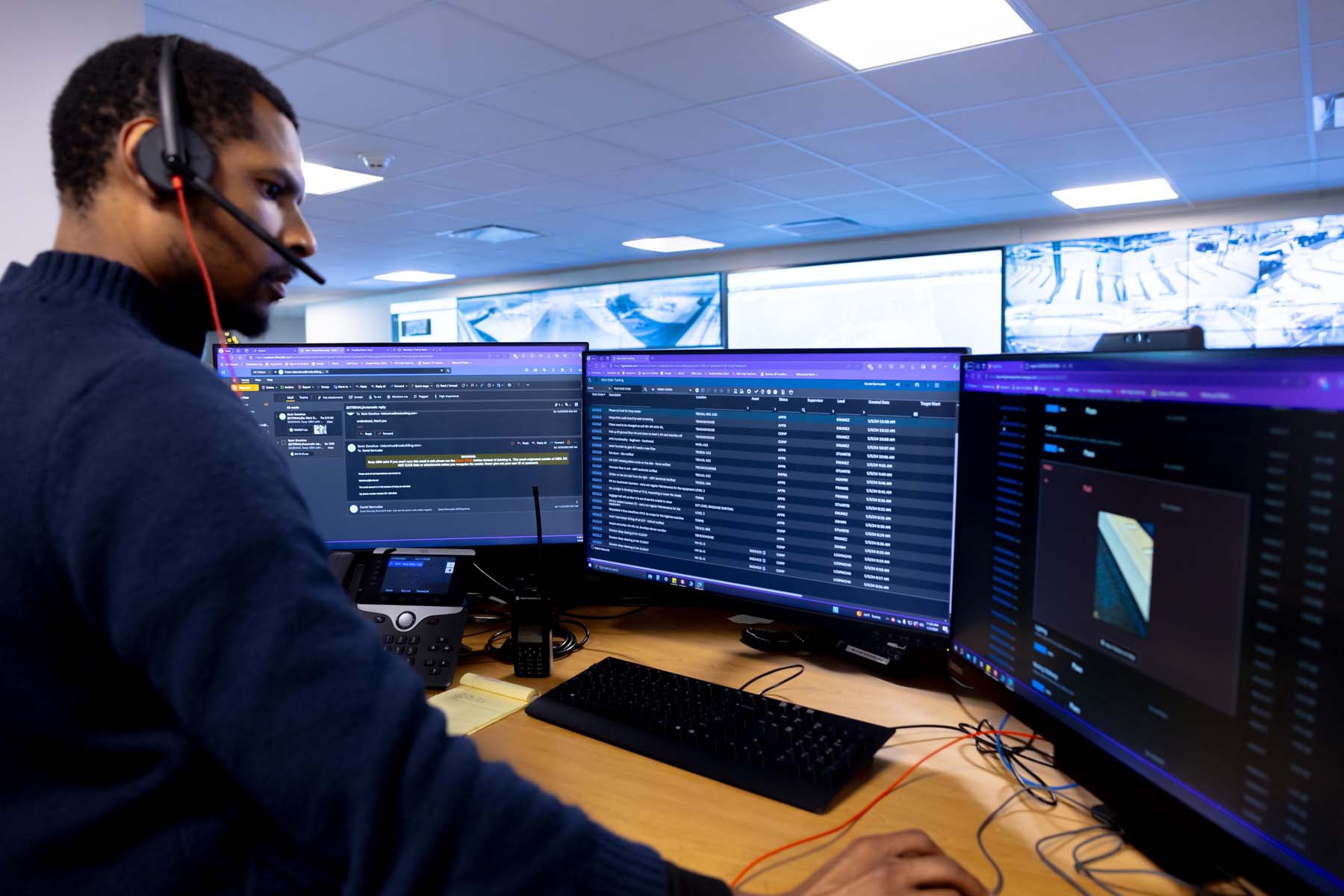 A person with a headset answers a call at their desk.