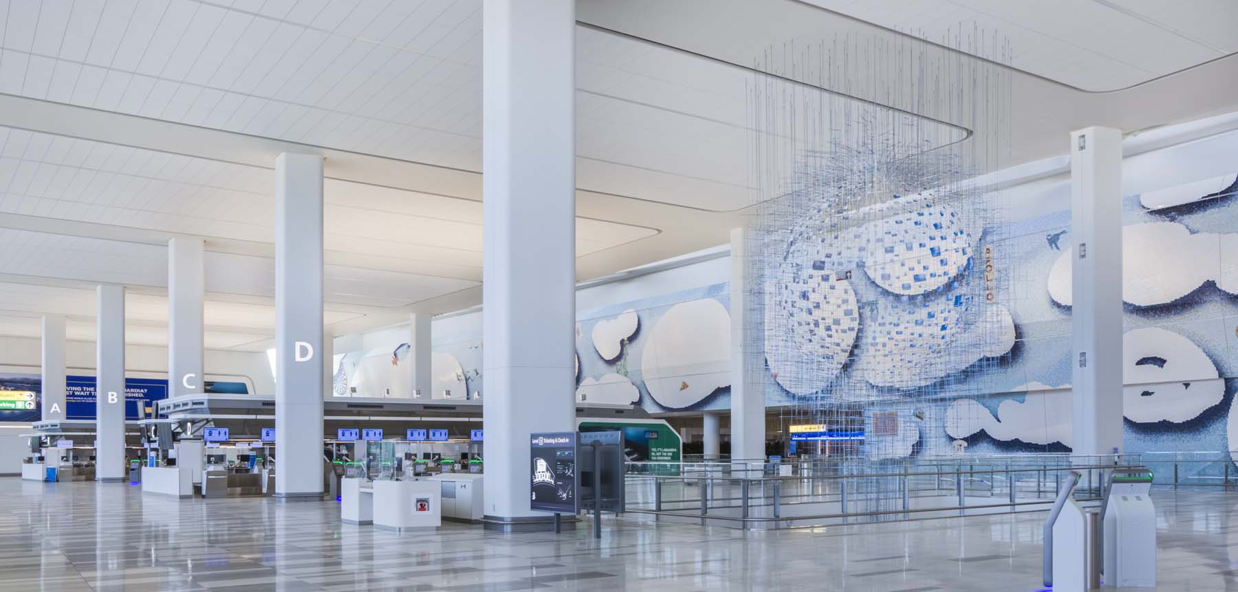 LaGuardia Terminal B is empty of travelers but has a blue mural and art installation.