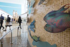 A close up of a steel fish art installation in an airport.