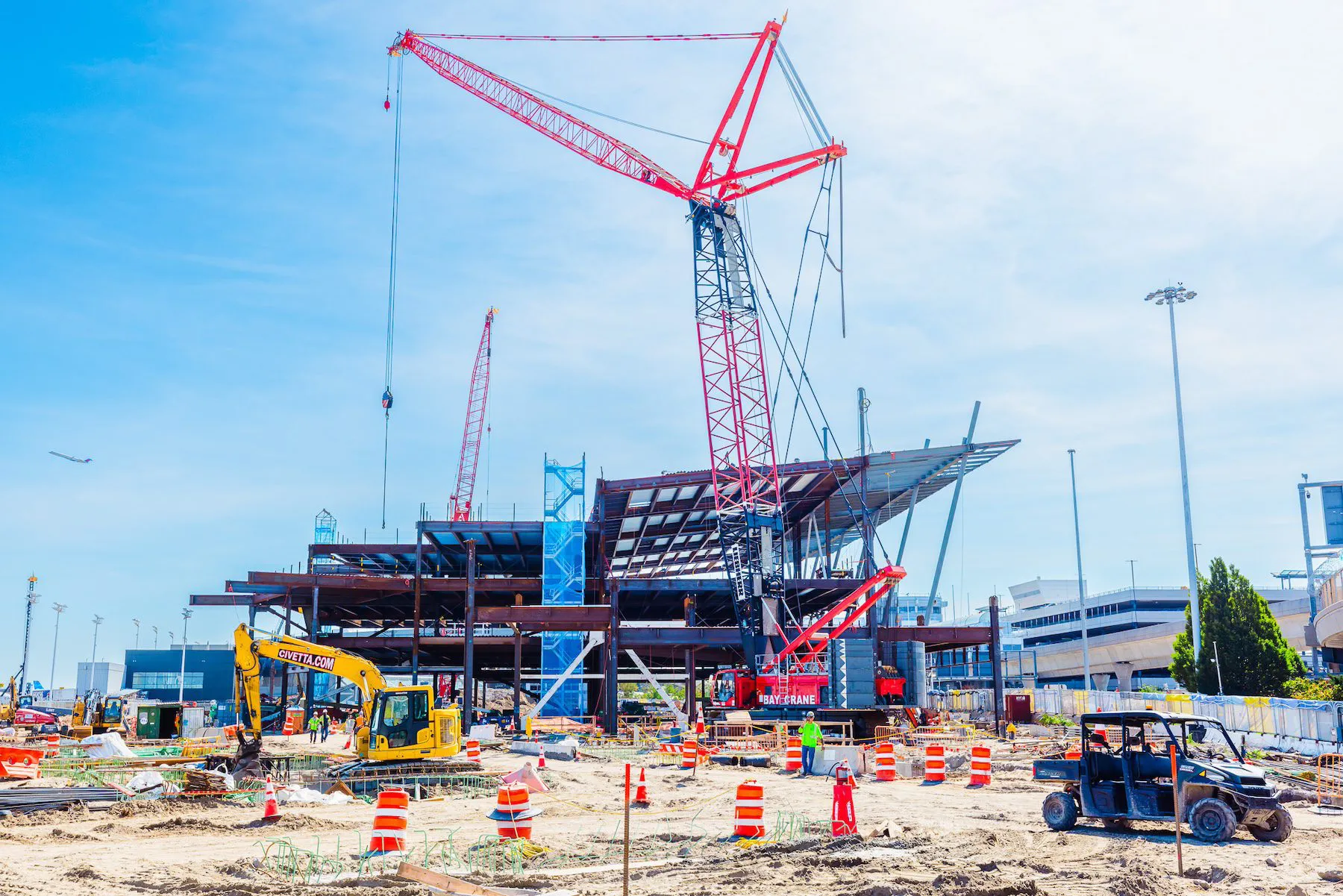 Busy construction site with large crane and heavy machinery.