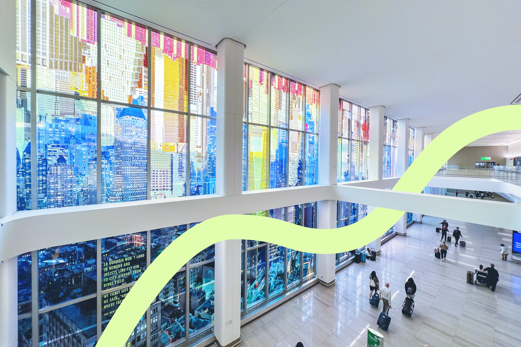 A spacious airport terminal with large colorful windows depicting a city skyline, passengers walking and pulling luggage.